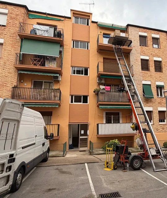 Plataforma elevadora pujant caixes de mudança a un tercer pis sense ascensor a Arenys de Mar