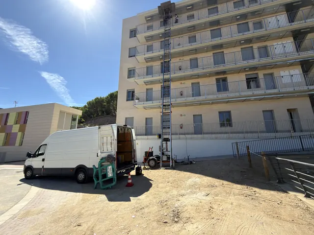 Furgoneta de mudances i plataforma elevadora treballant en una mudança a Arenys de Mar