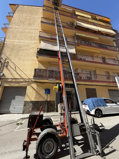 Plataforma elevadora muntada en un edifici d'habitatges amb balcons a Arenys de Mar